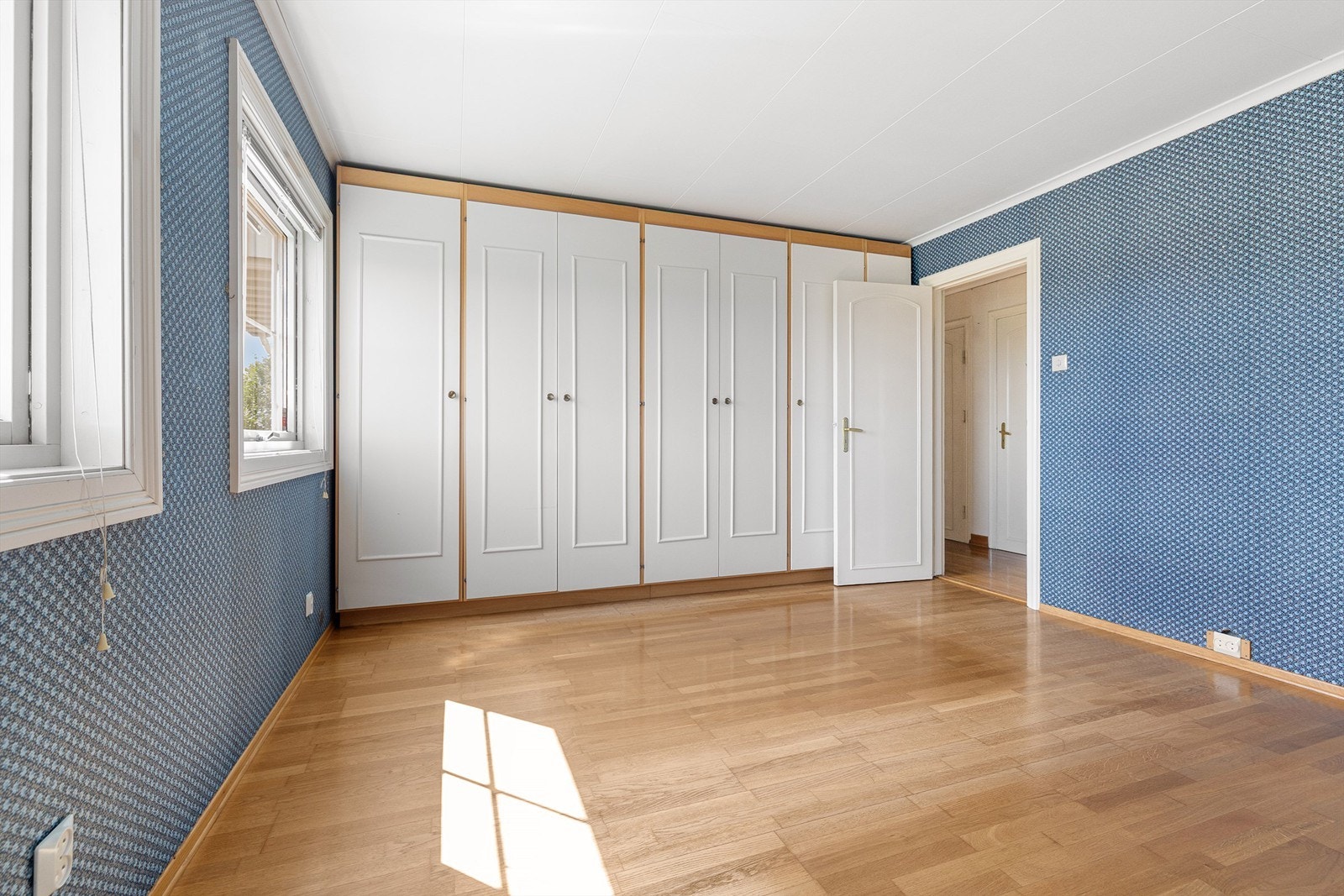 Innebygd garderobeskap dekker hele den ene veggen. Galleribilde