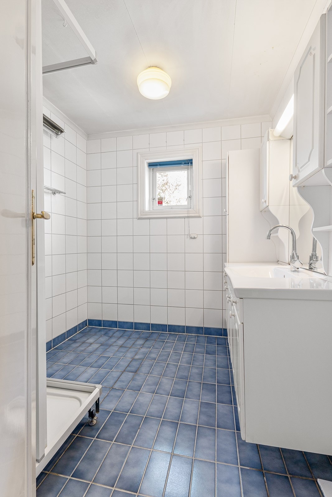 Flislagt bad med vindu som gir naturlig dagslys og mulighet for lufting. Galleribilde