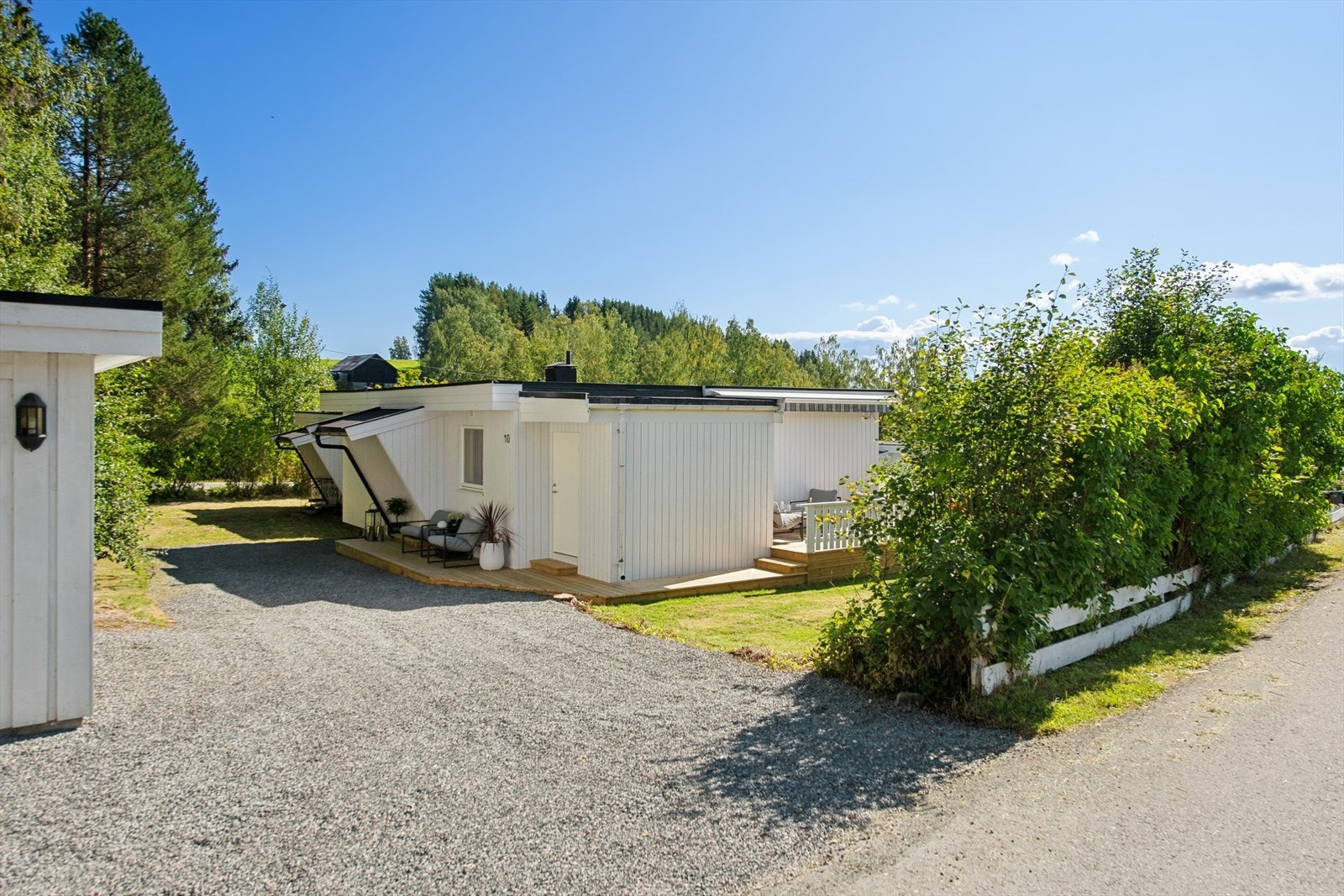 Egen parkeringsplass på gruset gårdsplass, med installert elbillader. Galleribilde