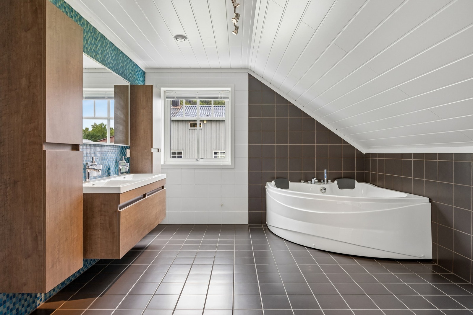 Badet er innredet med toalett, servantinnredning og badekar. Galleribilde