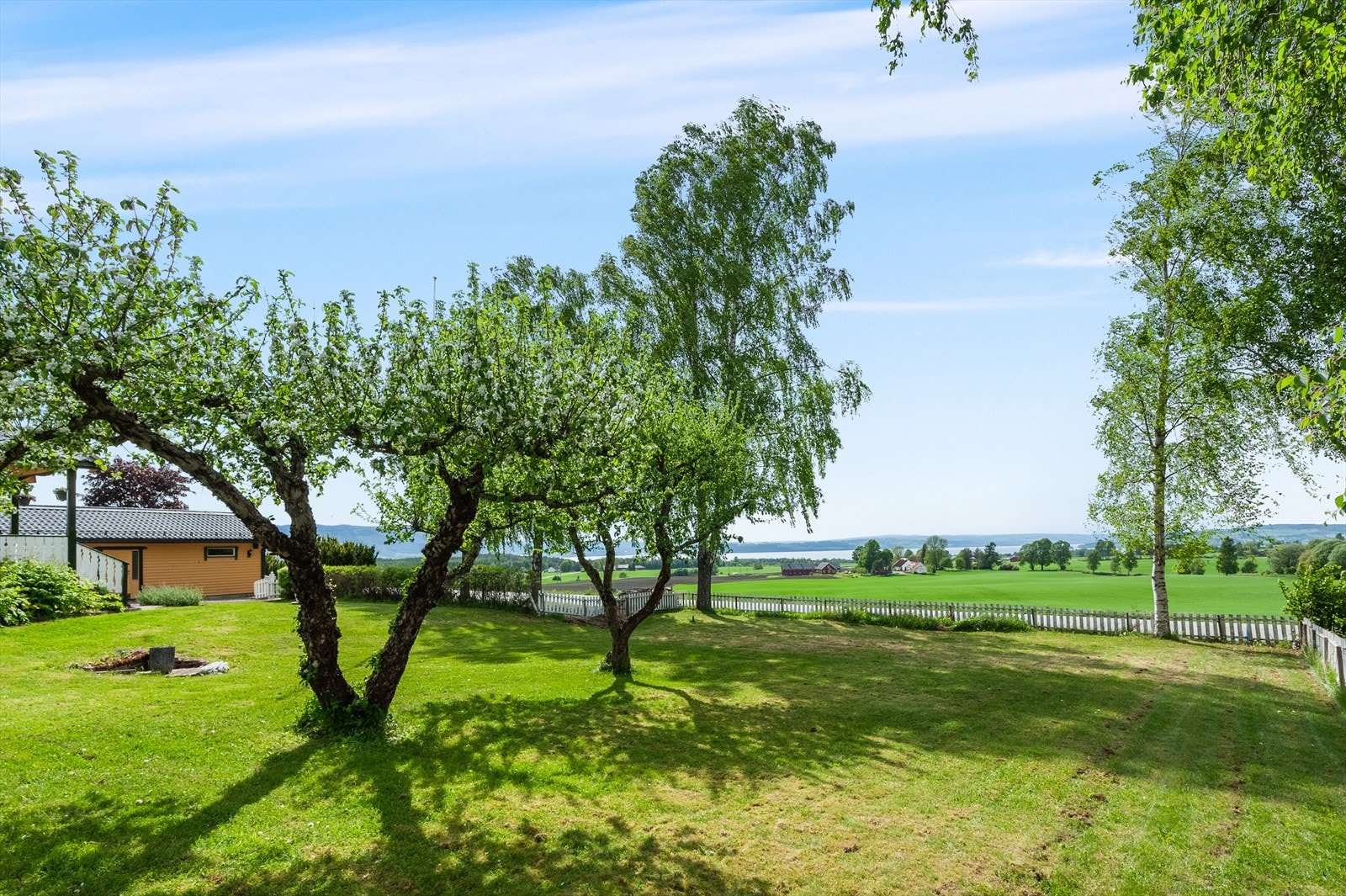 Fra hagen har man en flott og vidstrakt utsikt over det omkringliggende kulturlandskapet og mot Mjøsa. Galleribilde
