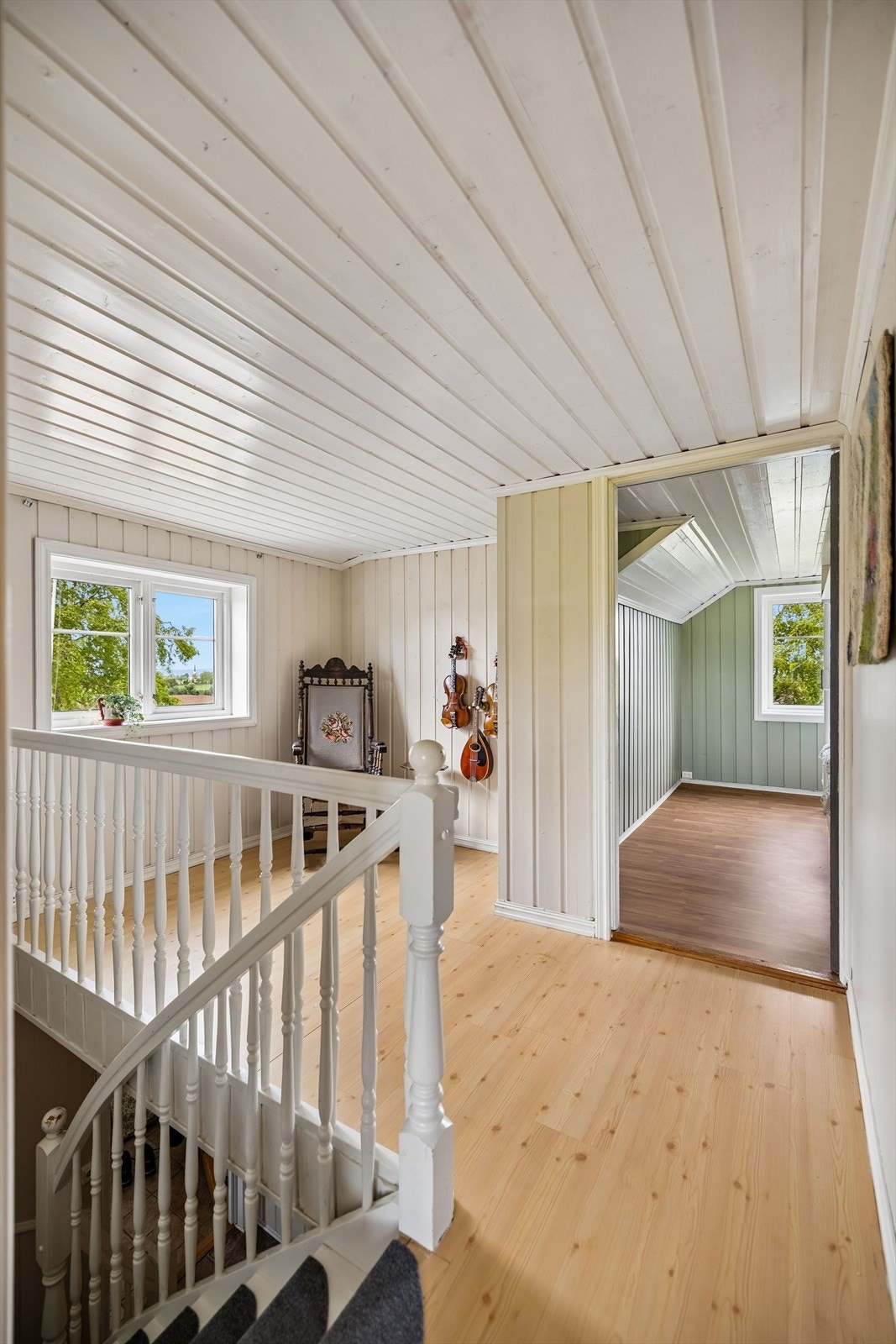 Trappen leder opp til en lys og åpen gang i andre etasje, med tilgang til etasjens rom. Galleribilde