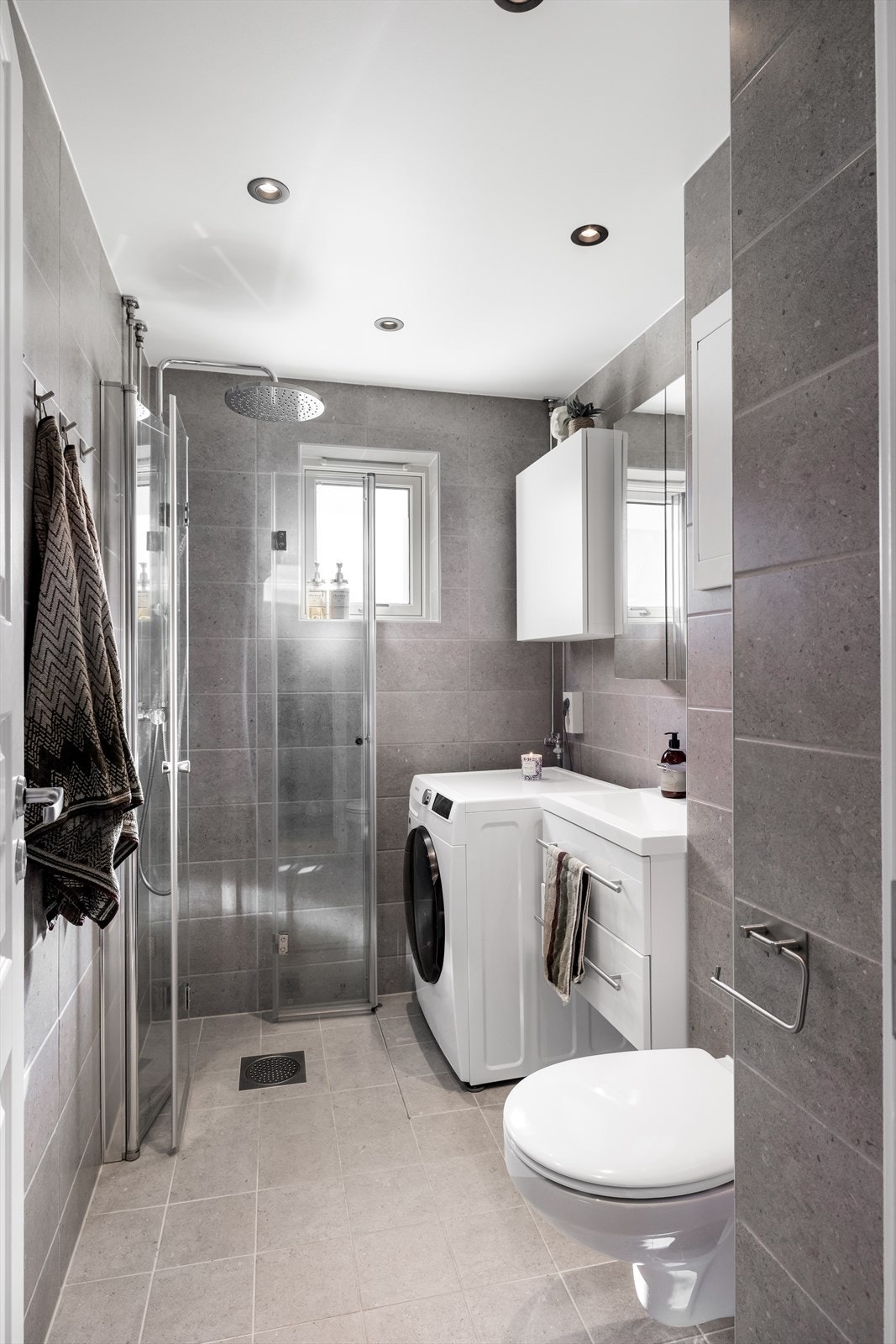 Badet ble rehabilitert i 2025 i regi av borettslaget, med fliser og gulvvarme. Praktisk innredet med dusjnisje med glassdører og opplegg for vaskemaskin. Galleribilde