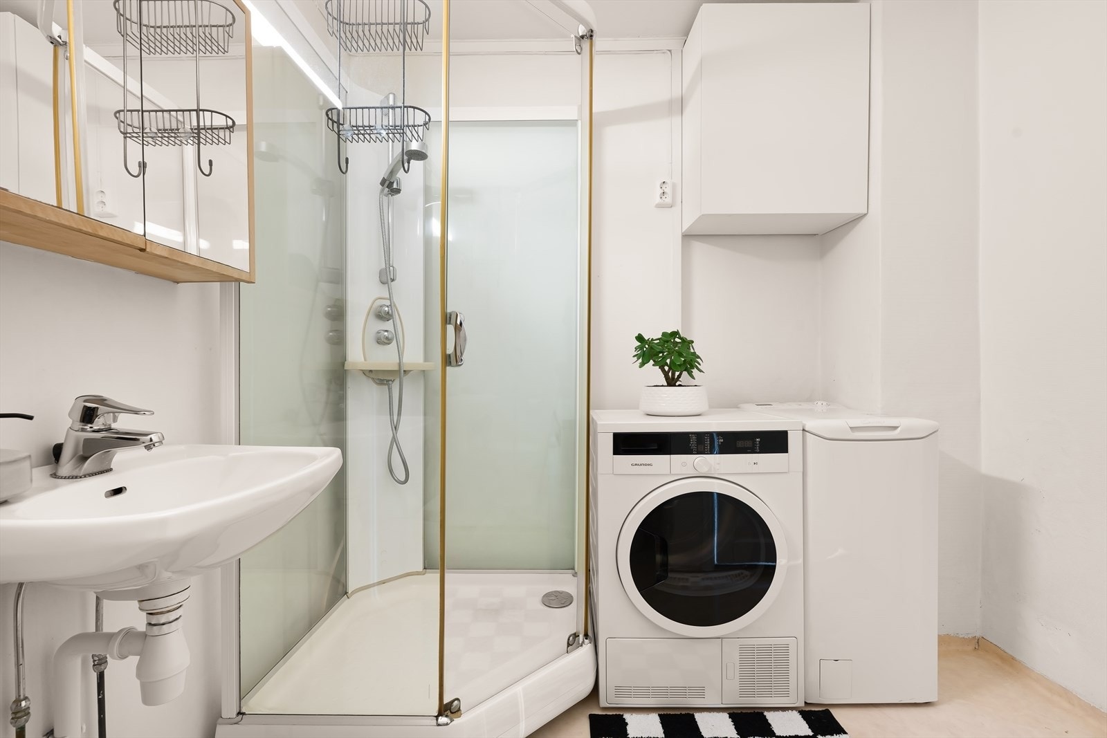 Badet har ukjent alder med gulvbelegg og våtromstapet. Rommet er utstyrt med bla. a. dusjkabinett og opplegg for vaskemaskin. Galleribilde