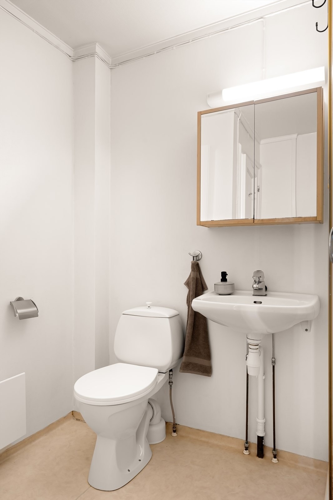 Videre har badet enkel servant med speilskap over og toalett. Galleribilde
