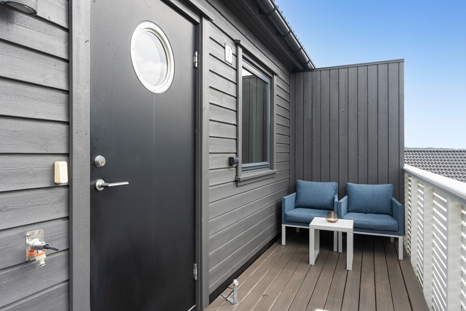 Inngangsparti/veranda med plass til liten sittegruppe. Galleribilde
