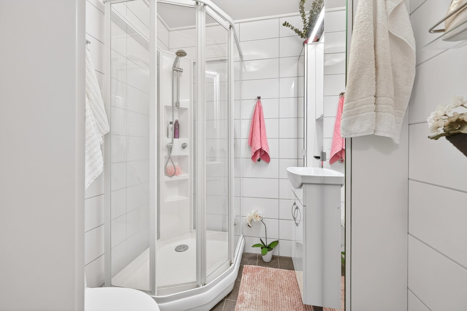 Det ene badet er tilknyttet soverommet og har fliser, gulvvarme og dusjkabinett. Galleribilde