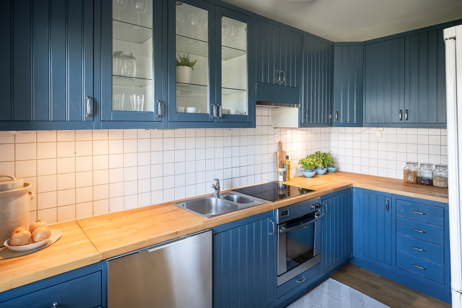 Pent hjørnekjøkken med blant annet integrert stekeovn og platetopp. Det medfølger også frittstående hvitevarer som oppvaskmaskin og kombinert kjøl- og fryseskap. Galleribilde