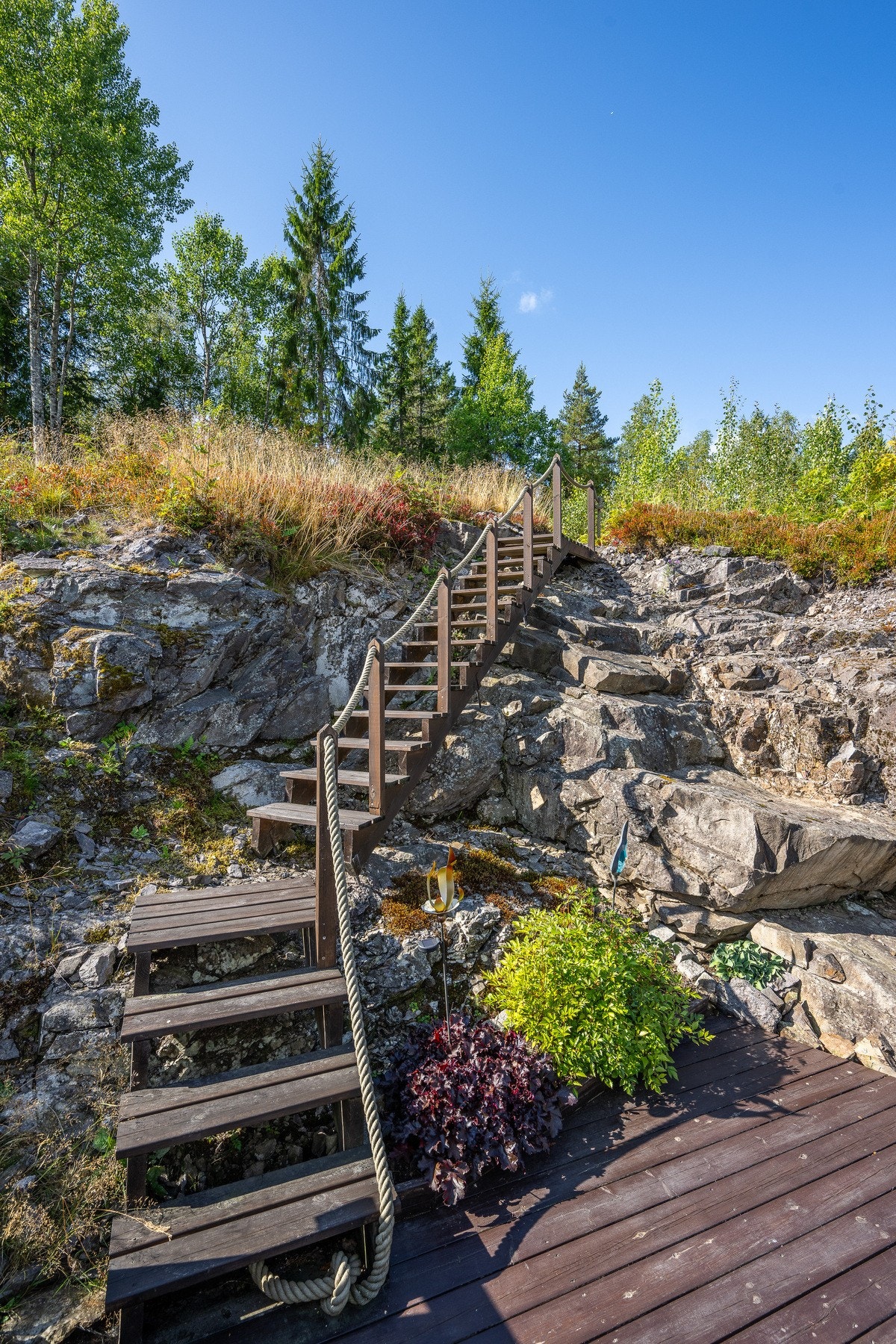 Sjarmerende uteplass med trapp som leder opp og rett ut i naturen. Galleribilde