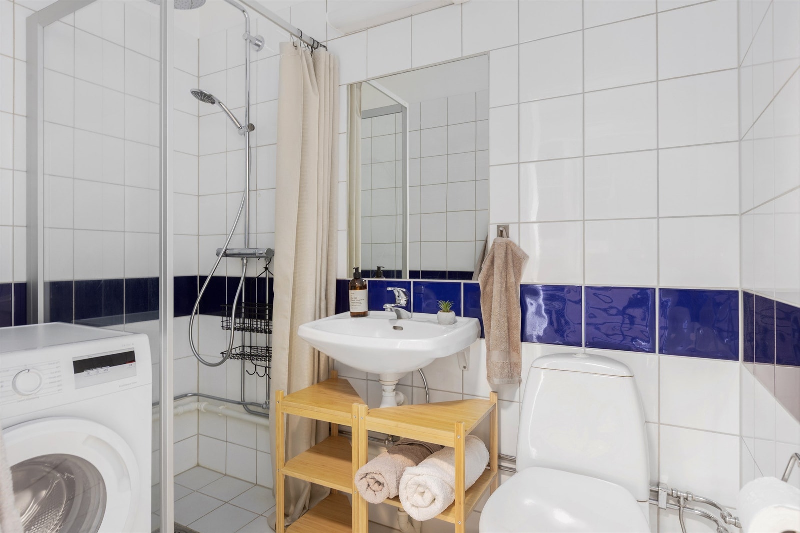 Flislagt bad med gulvvarme og opplegg for vaskemaskin. Galleribilde