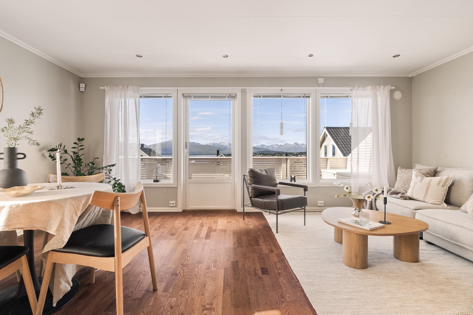 Stuen fremstår både lun og luftig, med store vindusflater som lar dagslyset strømme inn.