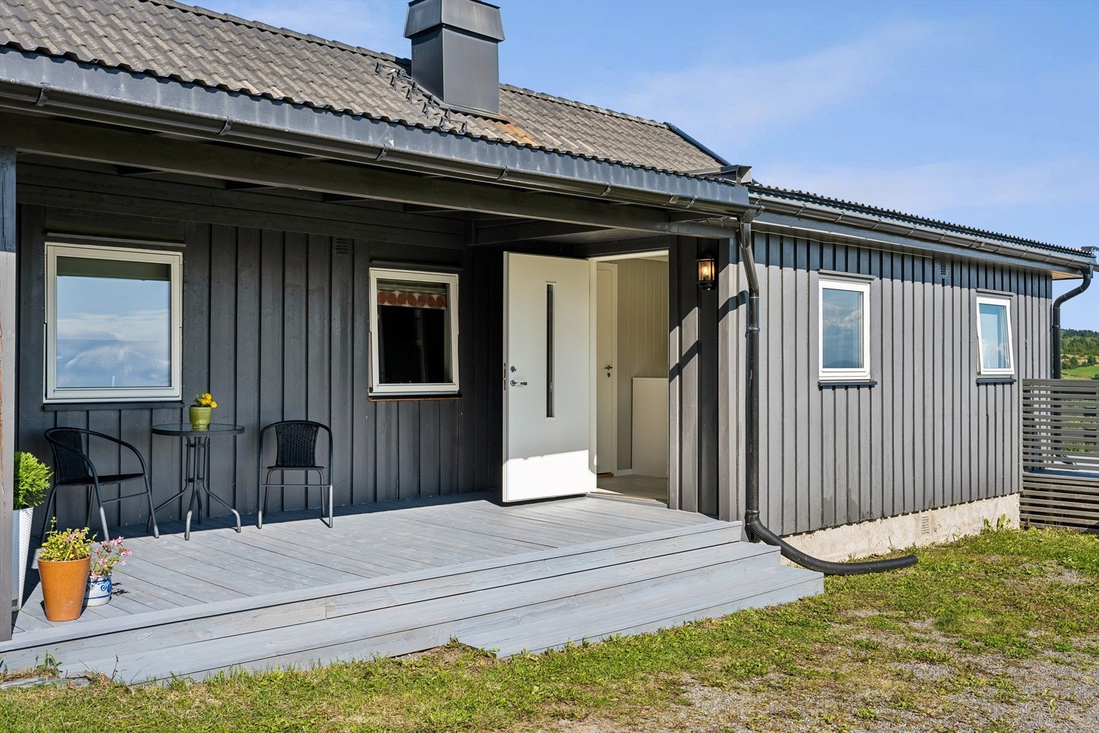 Overbygd inngangsparti med en liten, praktisk uteplass. Galleribilde