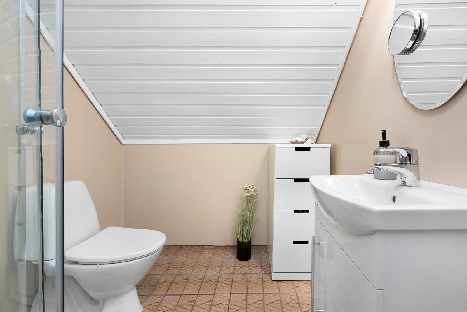 Badet er innredet med toalett, servant og dusjkabinett. Galleribilde