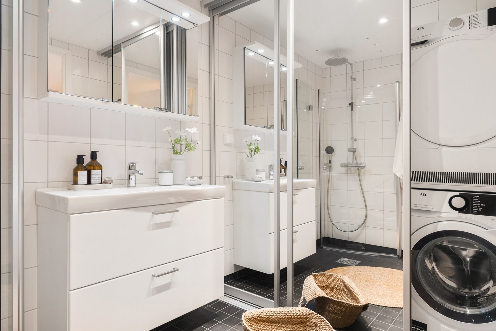 Badet består av dusj med glassvegger, vegghengt toalett, baderomsinnredning og opplegg for vaskemaskin og tørketrommel bak skyvedøren. Galleribilde