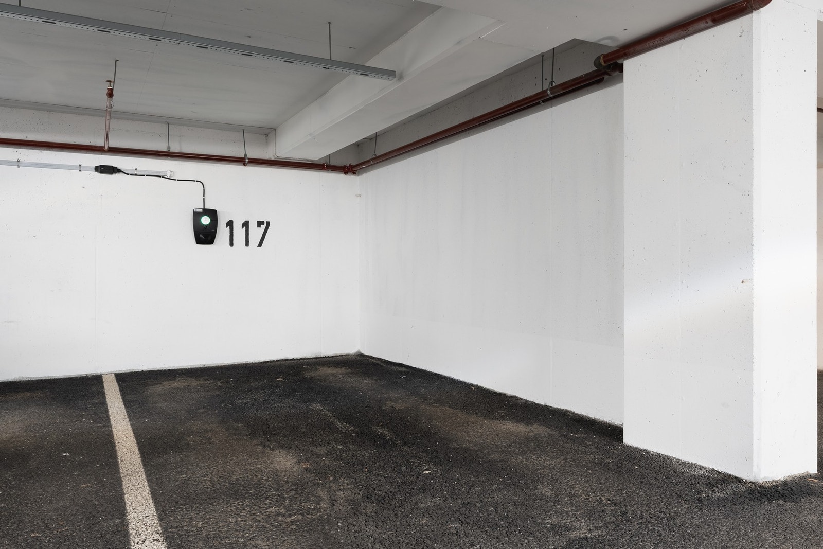 Fast parkeringsplass i garasjeanlegg med el-bil lader. Galleribilde