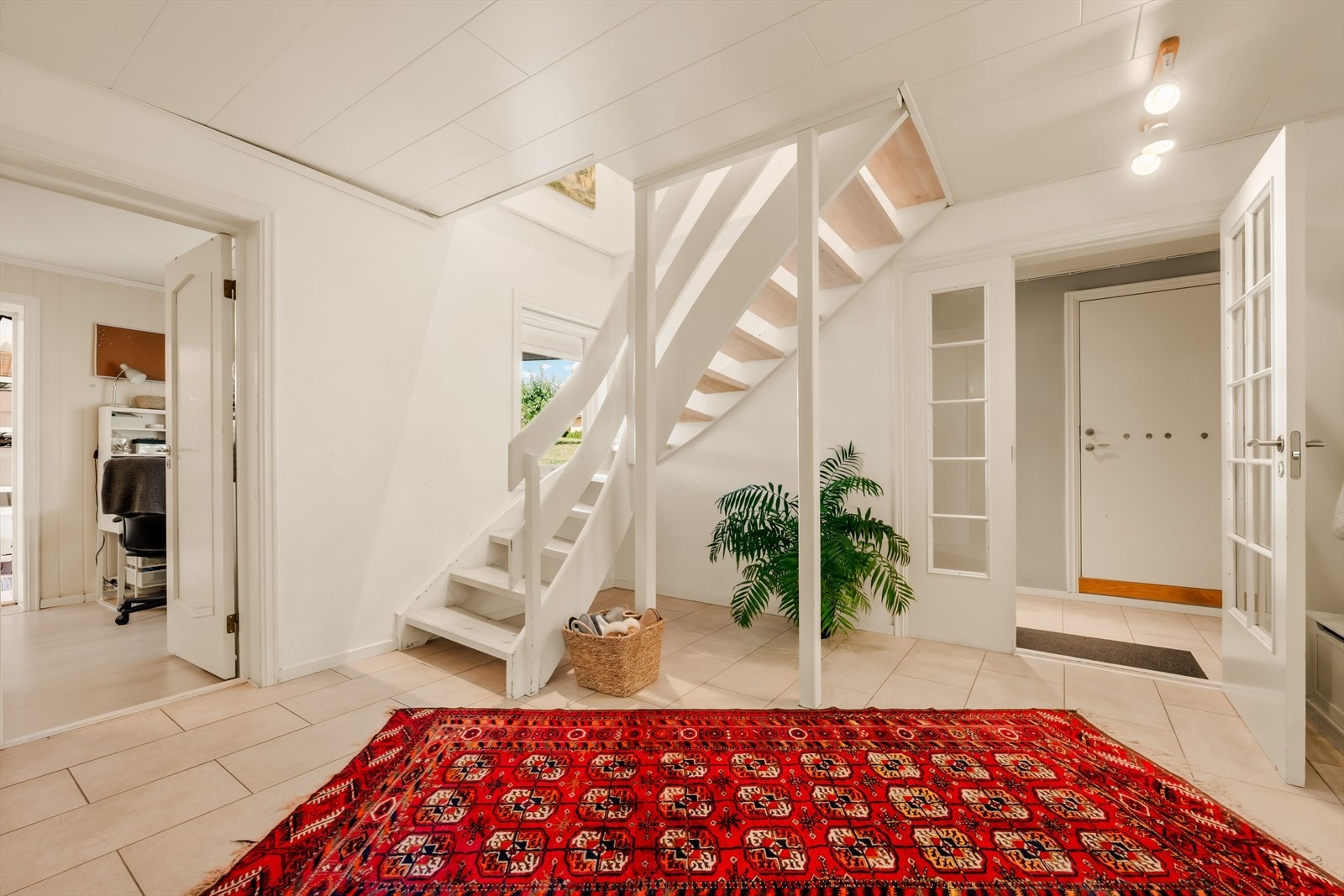Innbydende entré i underetasjen med malt tretrapp opp til hovedetasjen. Galleribilde