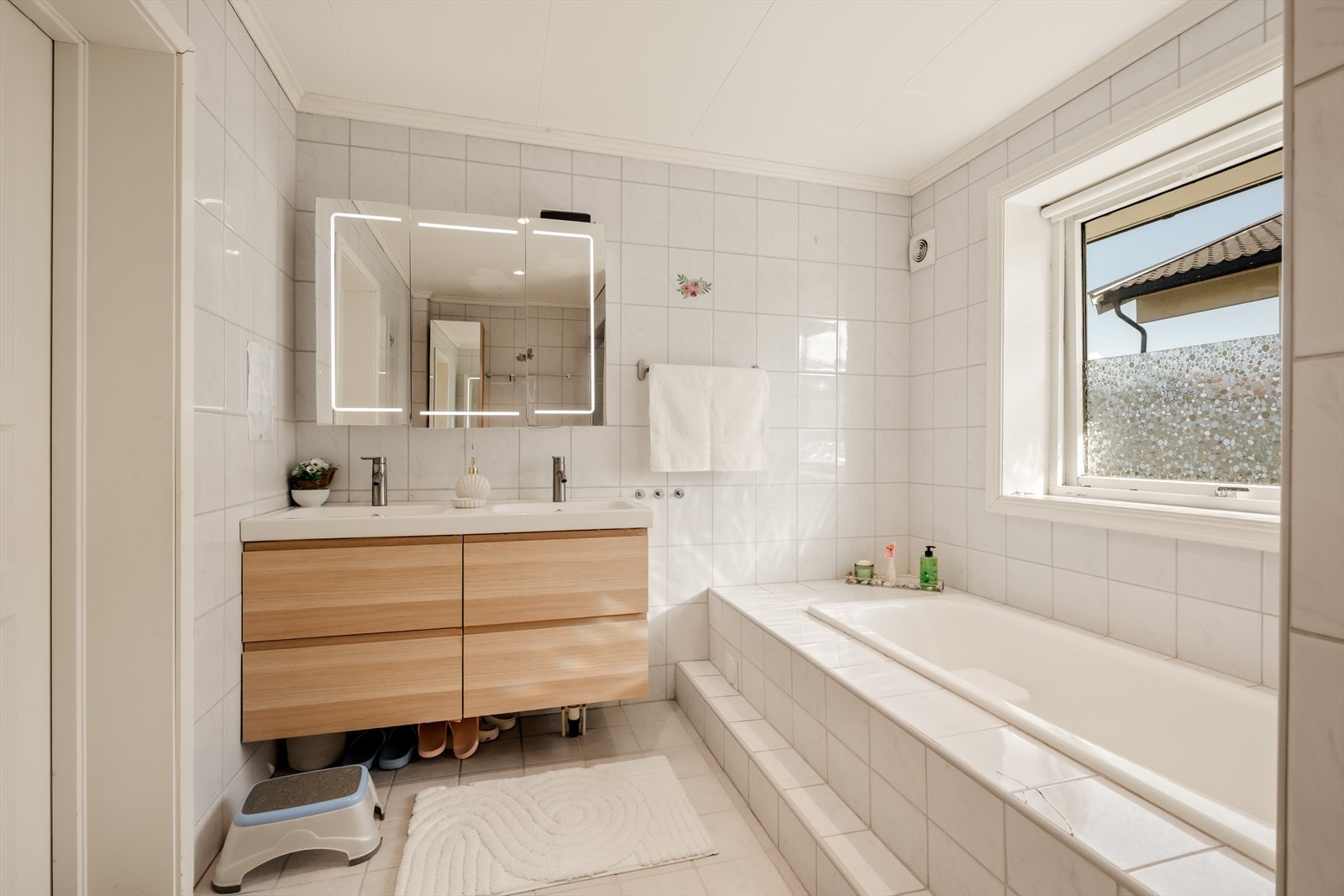 Badet i 1. etasje har flislagt gulv med gulvvarme og innebygget badekar. Galleribilde