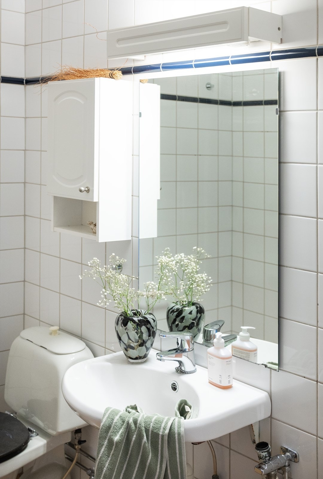 Baderommmet er utstyrt med opplegg for vaskemaskin, wc, åpen dusj og servant hvit keramisk, og ettgreps krummet armatur fra Oras. Galleribilde