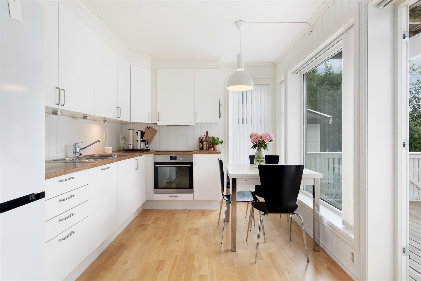Fint og tidlaust kjøken med lyse slette frontar og benkplate i laminat. Kjøkenet har integrerte kvitevarer beståande av oppvaskmaskin, platetopp og steikeomn, og elles plass til frittståande kjøleskåp. Galleribilde