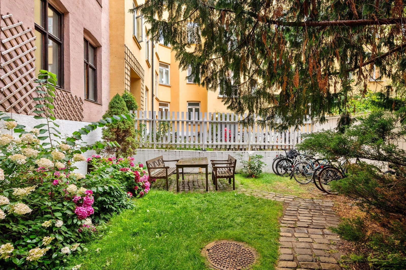 Her er det både hyggelig sittegruppe, plen, blomster og trær, samt sykkelparkering. Galleribilde