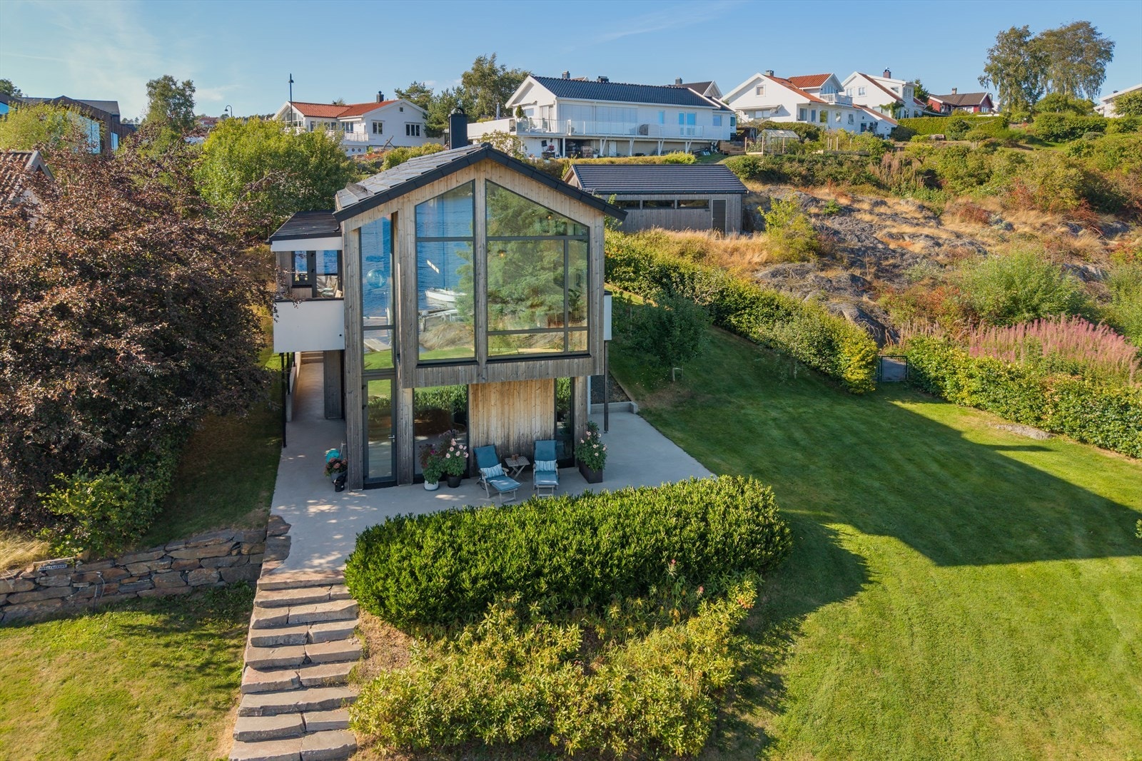 Det er flott hage mellom huset og sjøen, samt flere fine uteplasser. Galleribilde