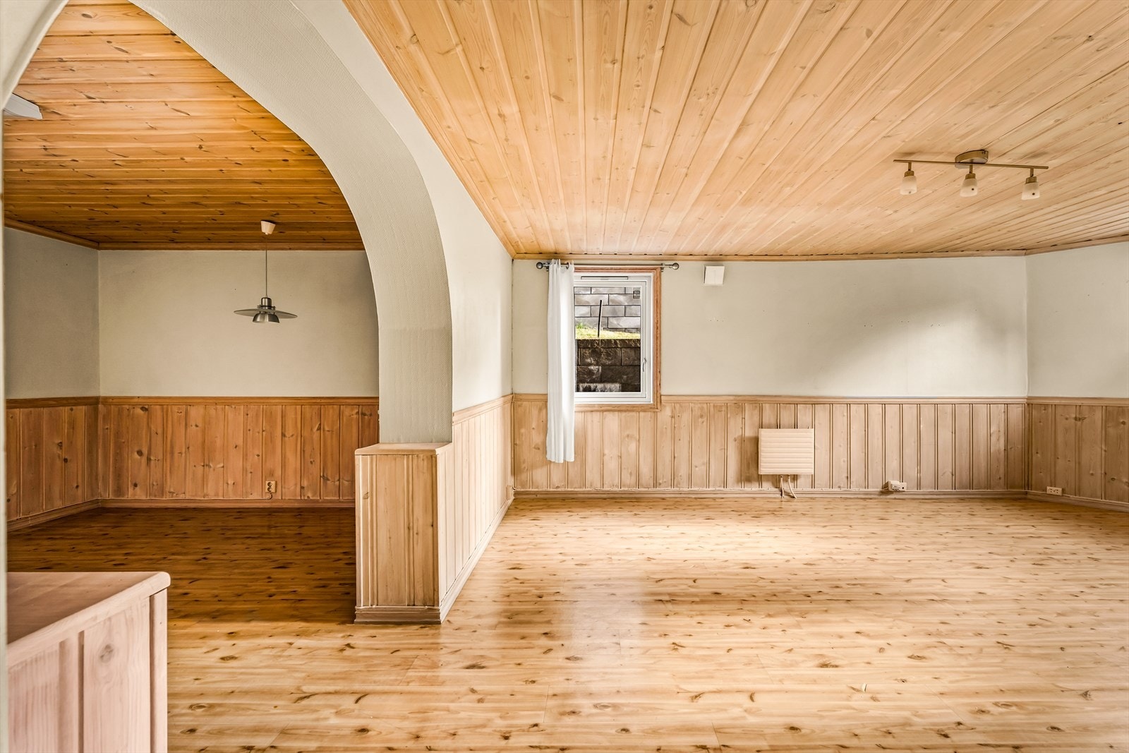 Stuen har panel på deler av veggene. Galleribilde
