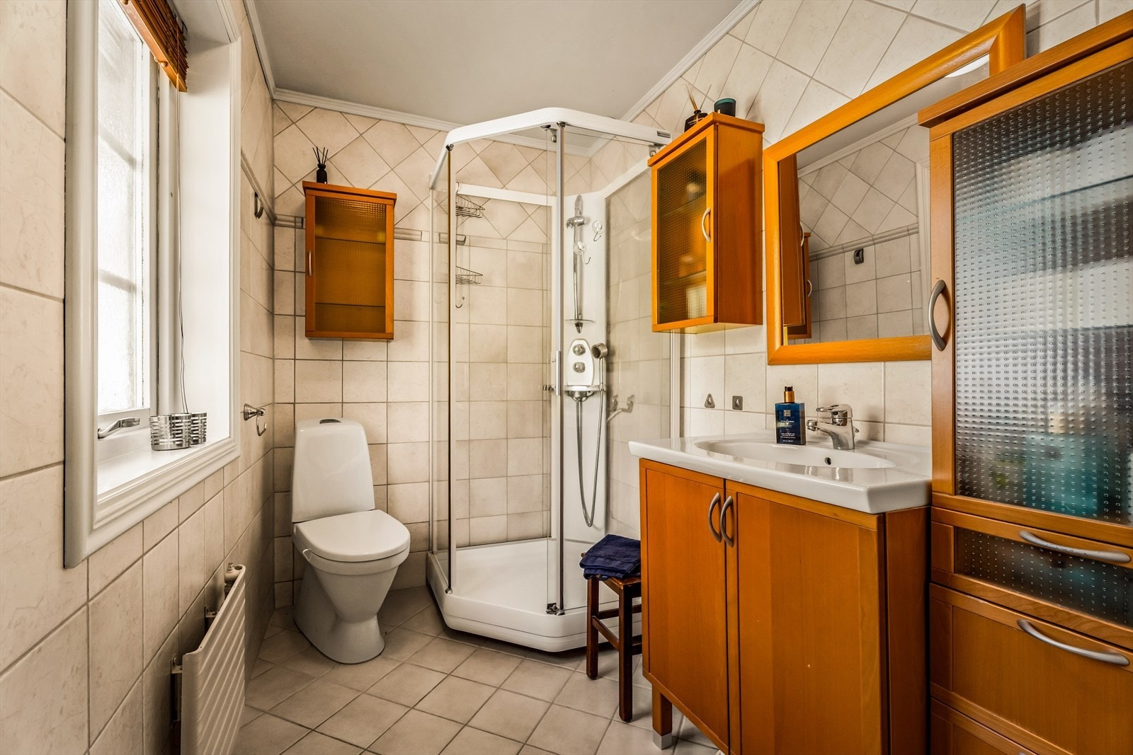 Badet er utstyrt med servantinnredning, toalett og dusjkabinett. Galleribilde