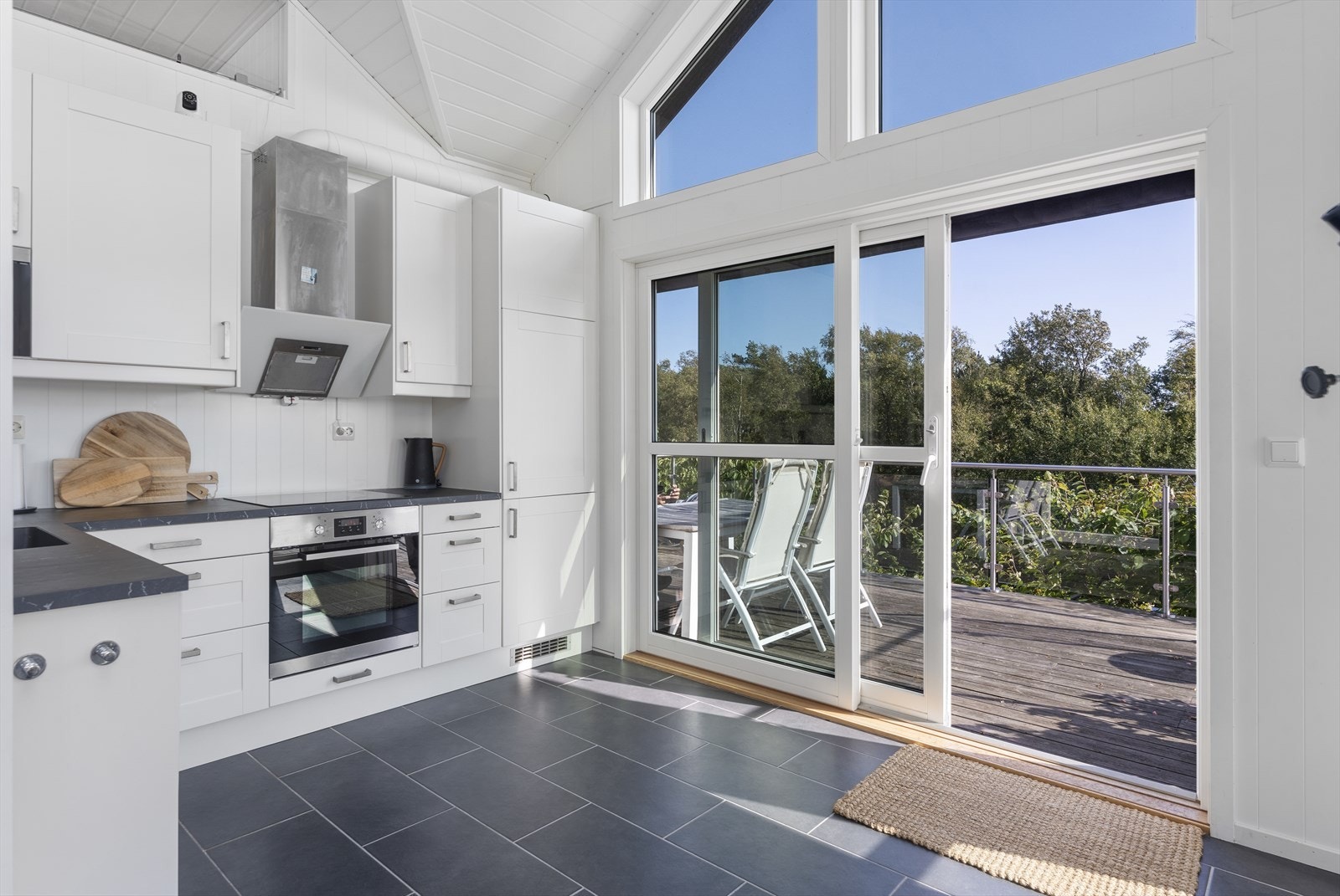 Skyvedør i tre med utvendig aluminiumsbekledning gir direkte utgang til uteplassen. Galleribilde