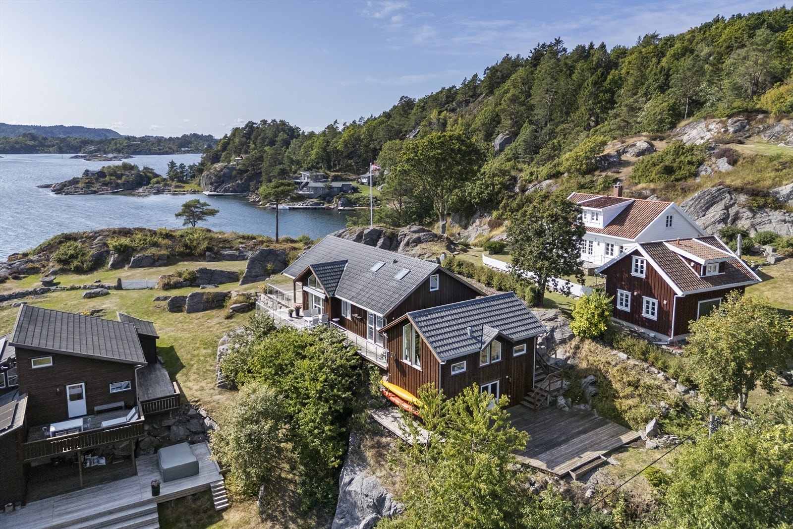 Fasaden er kledd med stående bordkledning og taket har steinbelagte stålplater. Galleribilde
