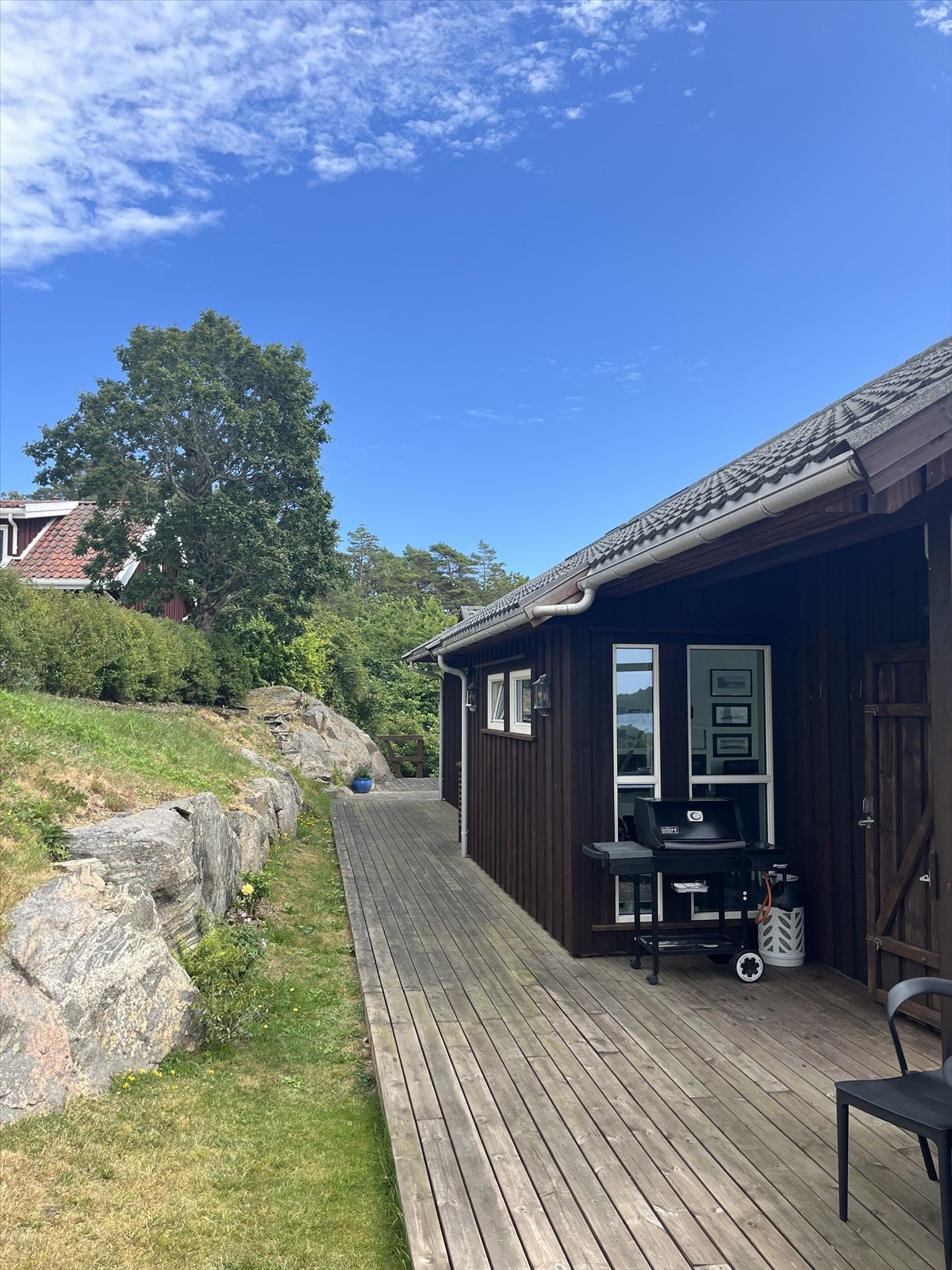 Selgers bilde. Uteplass langs siden av hytta med plass for grill. Galleribilde