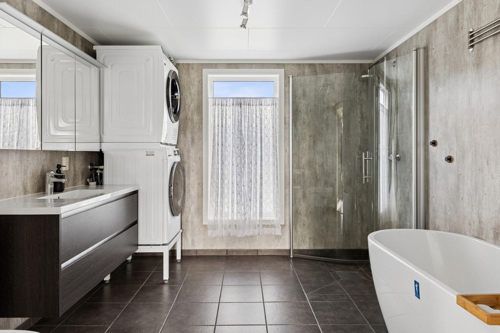 Badet er innredet med badekar, dusjhjørne, servantinnredning og opplegg for vaskesøyle. Galleribilde