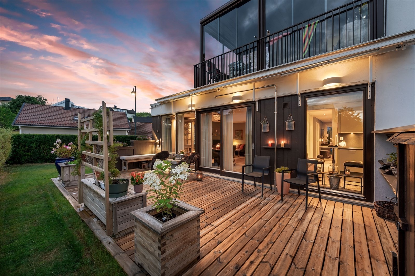 Store skyvedører i glass visker ut skillet mellom stue og terrasse. Galleribilde