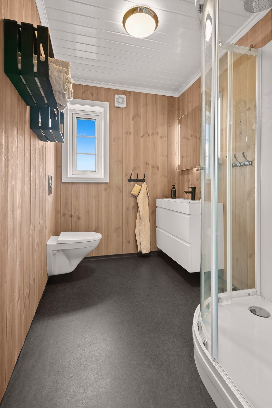Badet fra 2021 har belegg på gulv, panel på veggene og varmekabler i gulvet. Galleribilde
