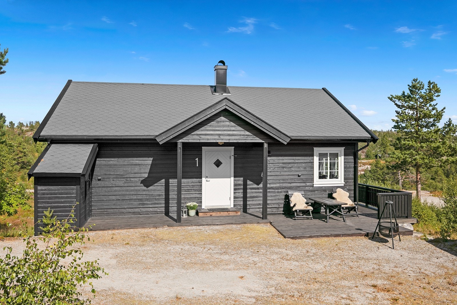 Tomten er opparbeidet med gruset adkomst og parkering, ellers naturtomt i form av fjell og naturlige skogvekster. Galleribilde