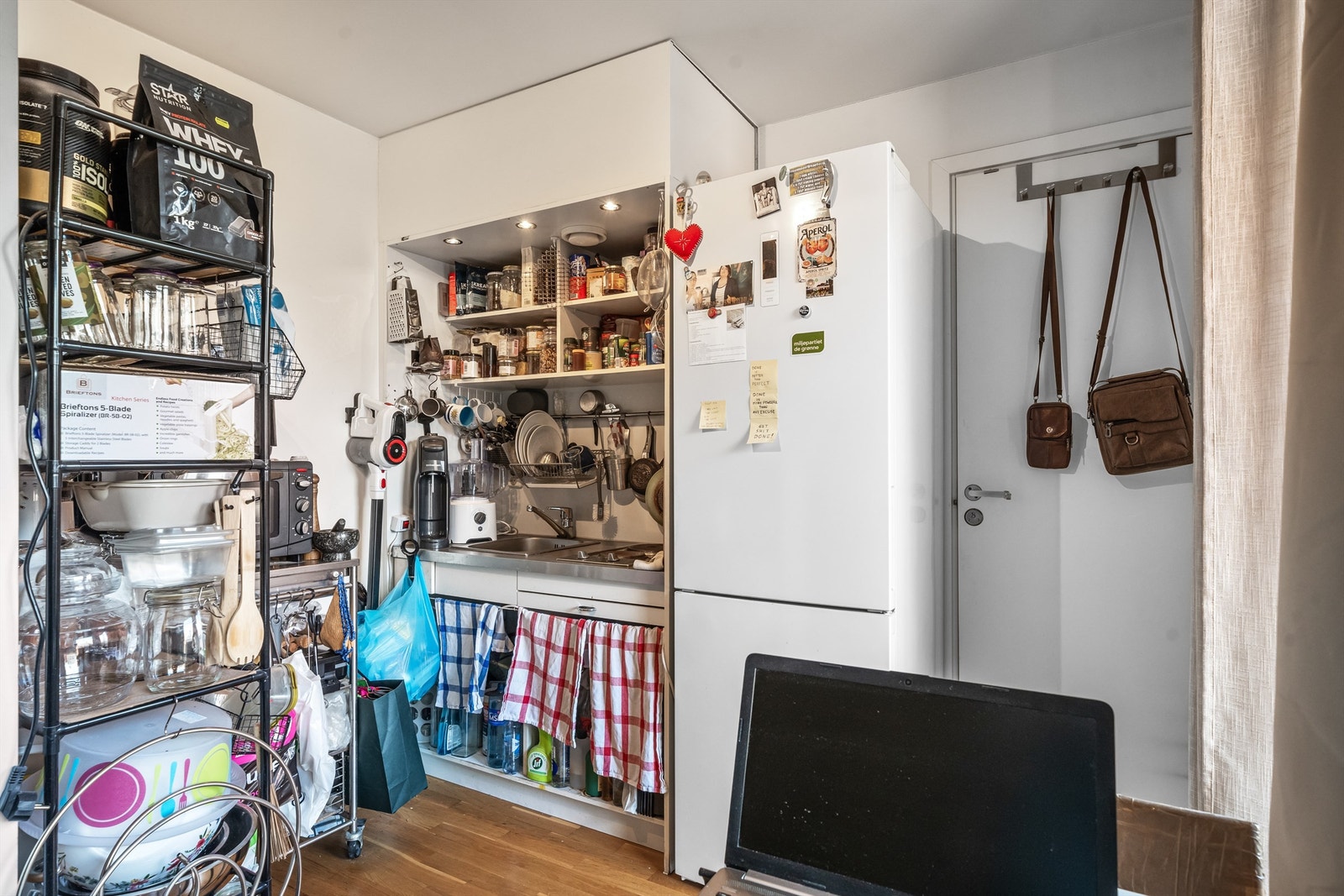 Hybelkjøkken med nedfelt oppvaskkum, platetopp og frittstående kjøleskap. Galleribilde