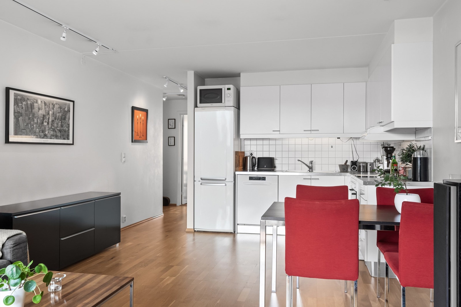 Åpen kjøkkenløsning mot stue med kjøkkeninnredning bestående av slette fronter og benkeplate av laminat. Galleribilde