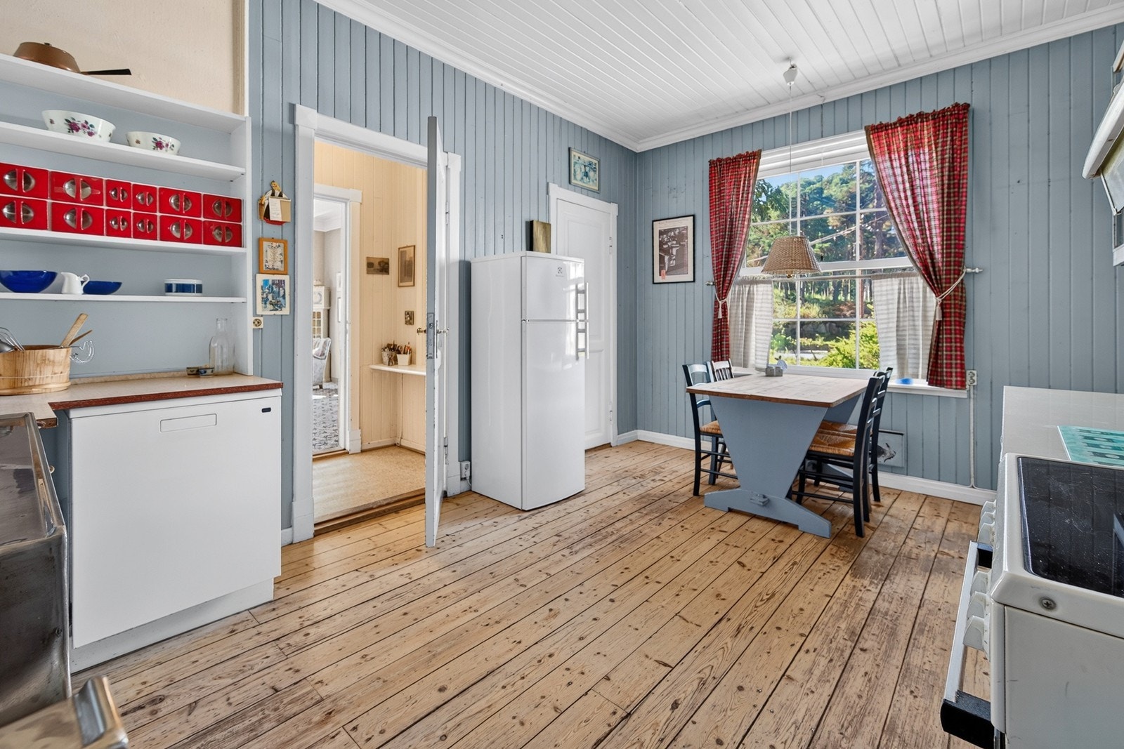 Lakket furugulv, malt panel og plass til spisebord under vindu Galleribilde