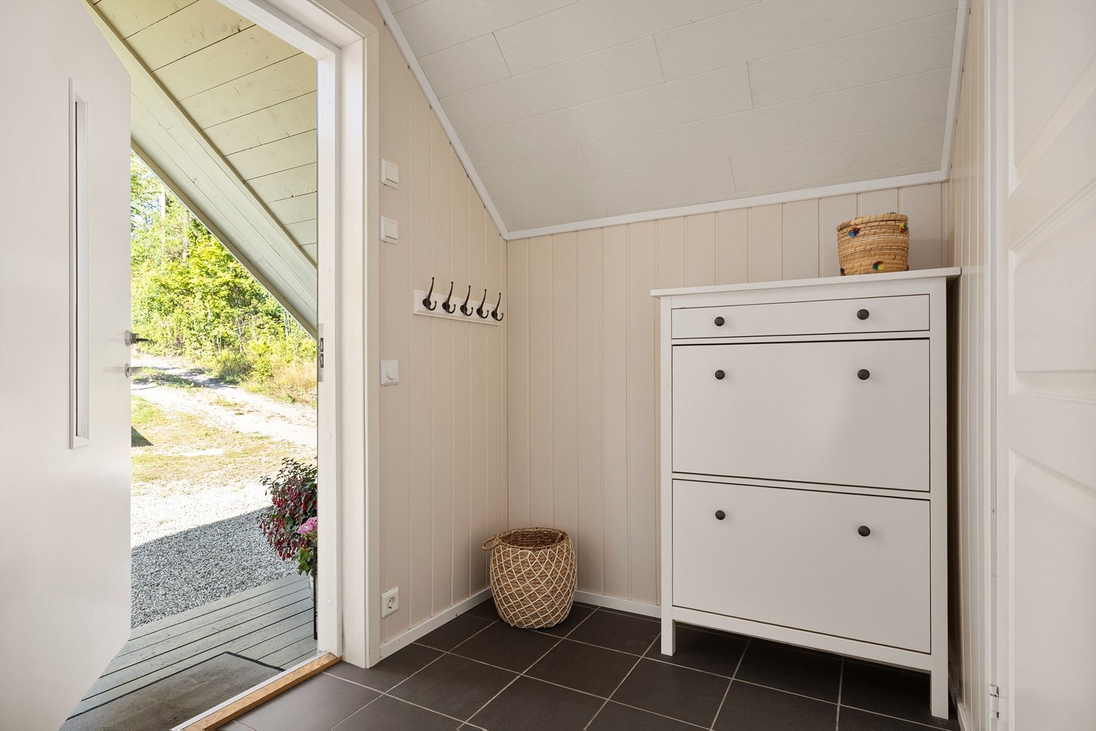 Entréen har flislagt gulv med varmekabler og malt panel på vegger og i himling. Galleribilde