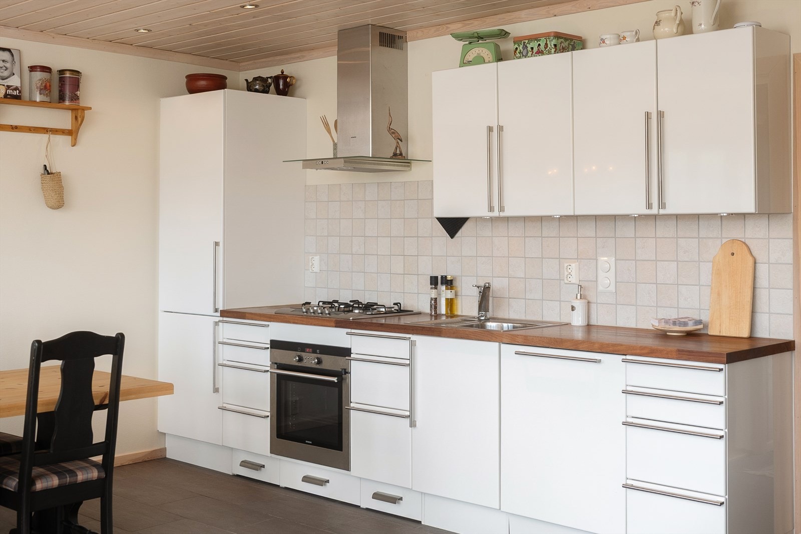 Kjøkken med heltre benkeplate, gassdrevet platetopp og integrerte hvitevarer. Galleribilde