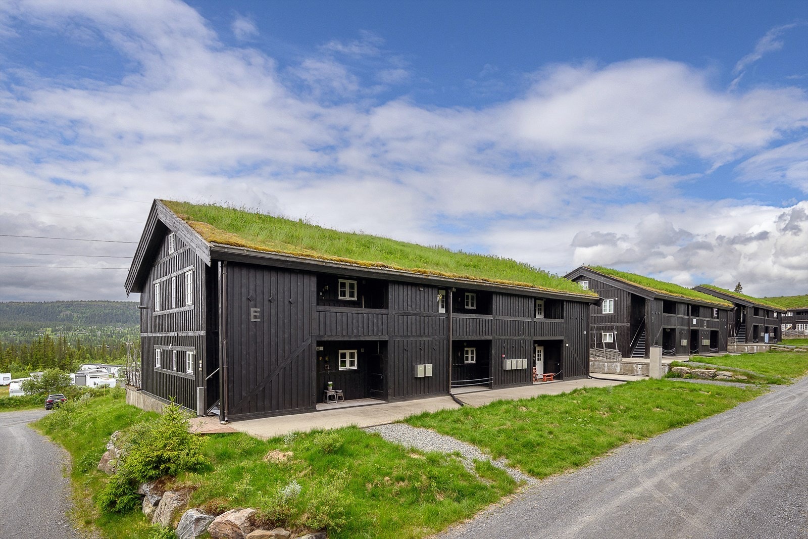 Bygget har stående panel og torvtak, og glir godt inn i fjellandskapet. Galleribilde