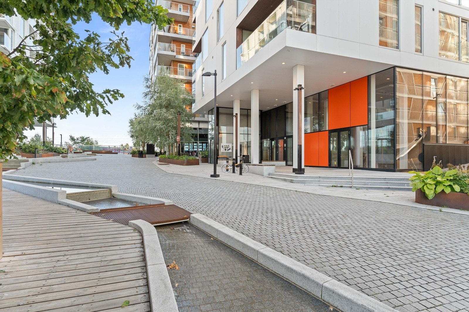 Dovrekvartalet er pent opparbeidet med grønt, bekk og brostein. Galleribilde