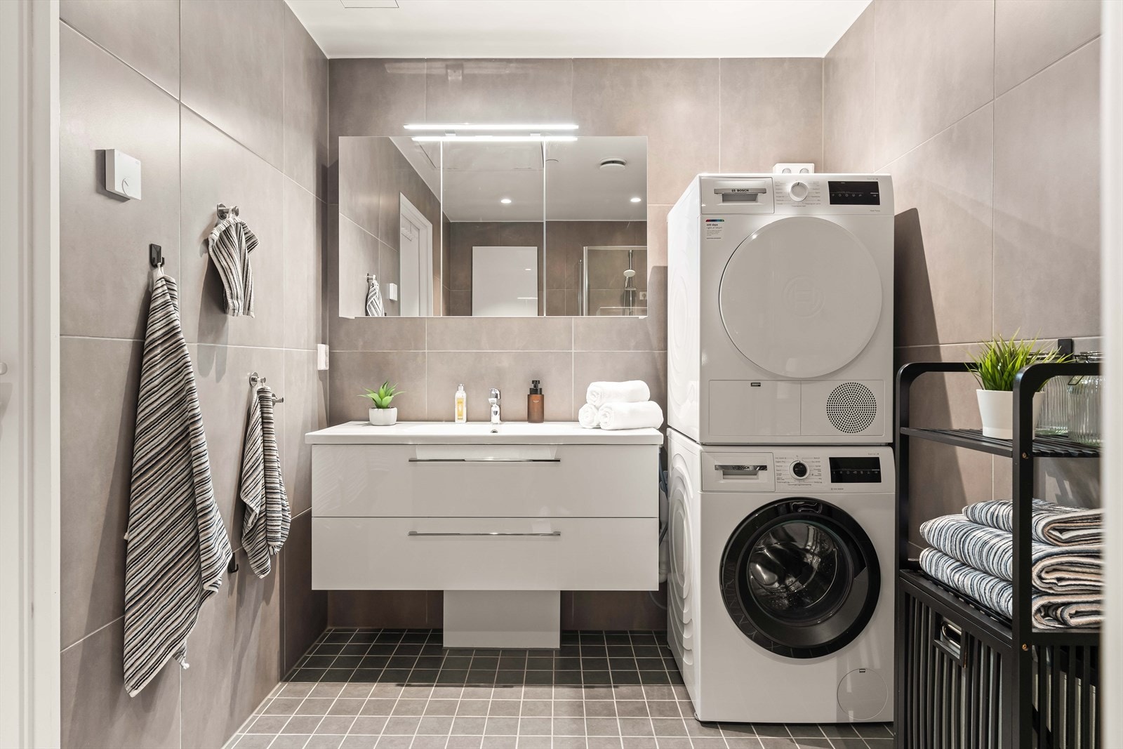 Badet er svært romslig og har flislagt gulv med gulvvarme og flislagte vegger. Det er også opplegg for vaskemaskin. Galleribilde