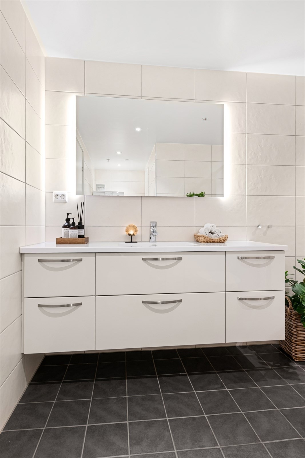 Badet er utstyrt med en romslig servantinnredning og speil med integrert belysning. Galleribilde