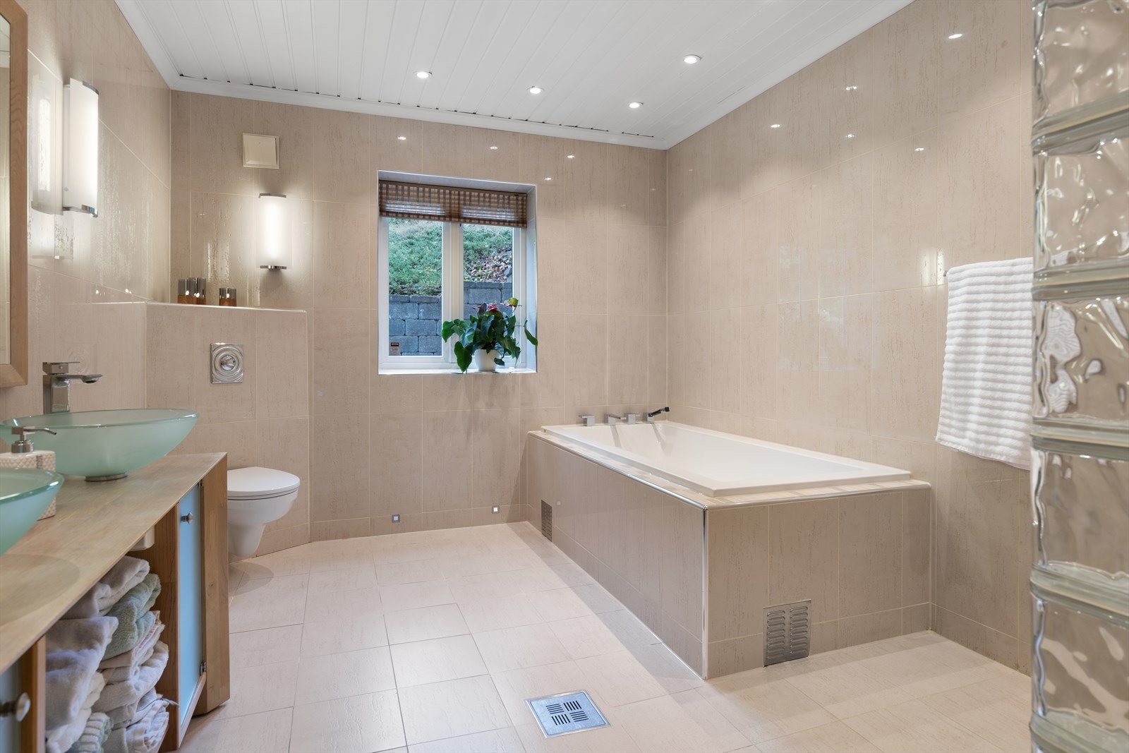 Badet er utstyrt med servantskap med 2 stk servantboller, speil og lys, badekar og stor dusjnisje Galleribilde