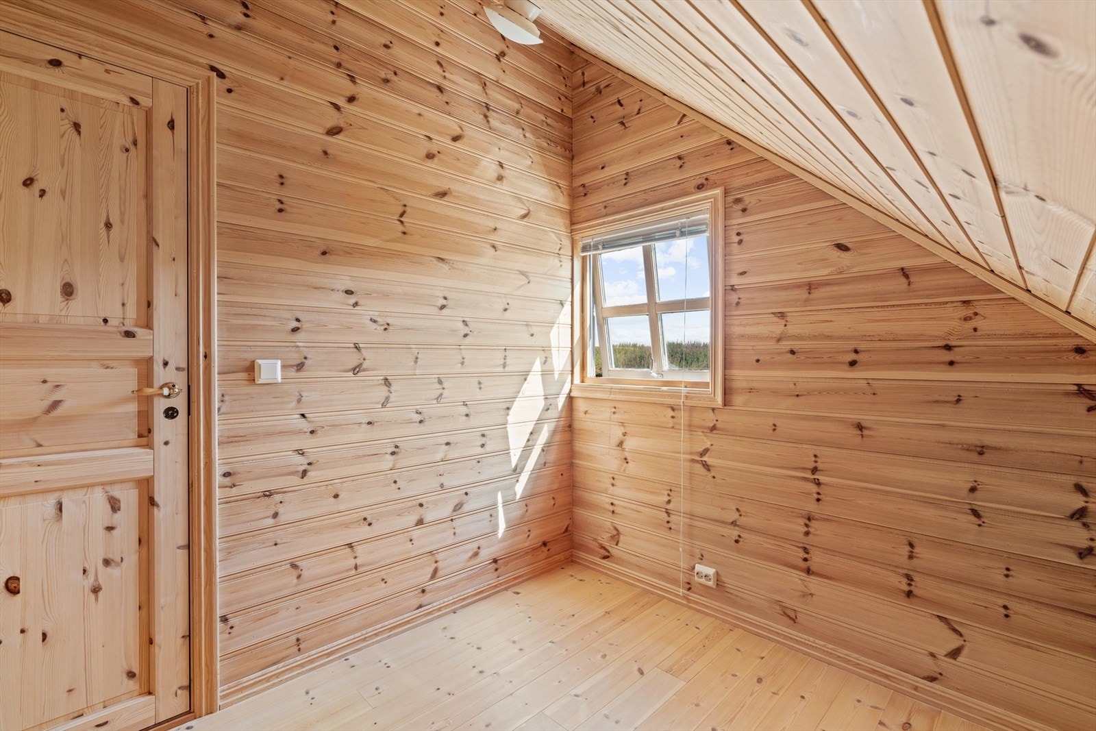 Innredet rom på loftet med trepanel på vegger og i tak. Galleribilde