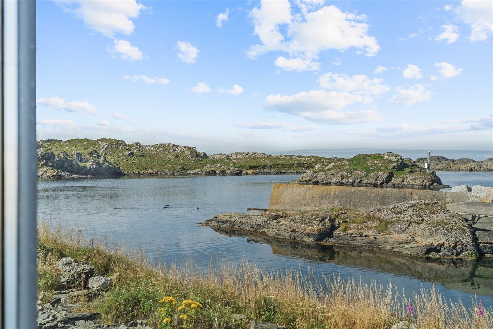 Fra vinduene kan man følge med på båtlivet og naturens skiftninger. Galleribilde