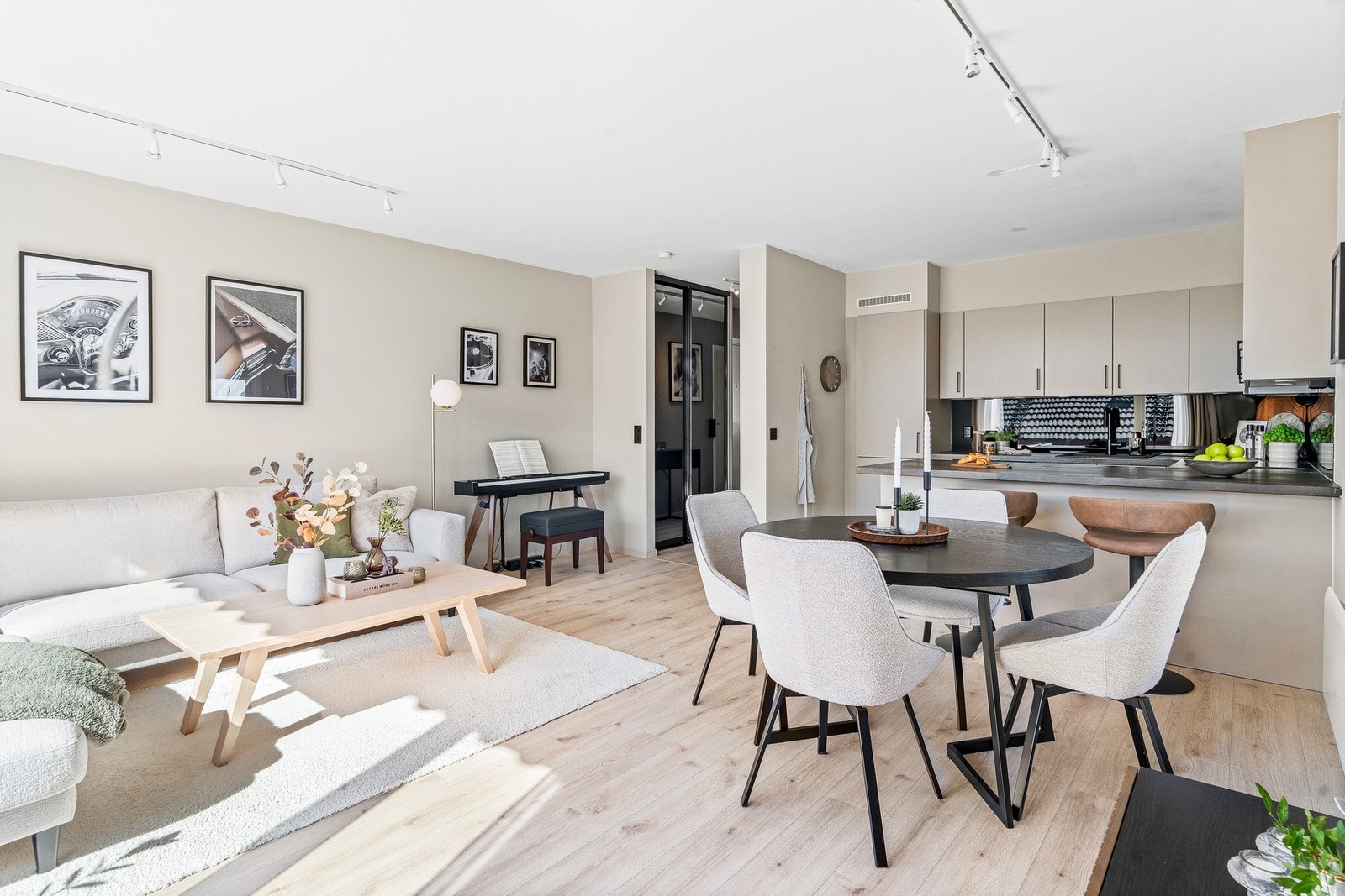 Oppholdsrommet fremstår lyst og innbydende, med laminatgulv og malte, lyse overflater som gir et moderne uttrykk. Galleribilde