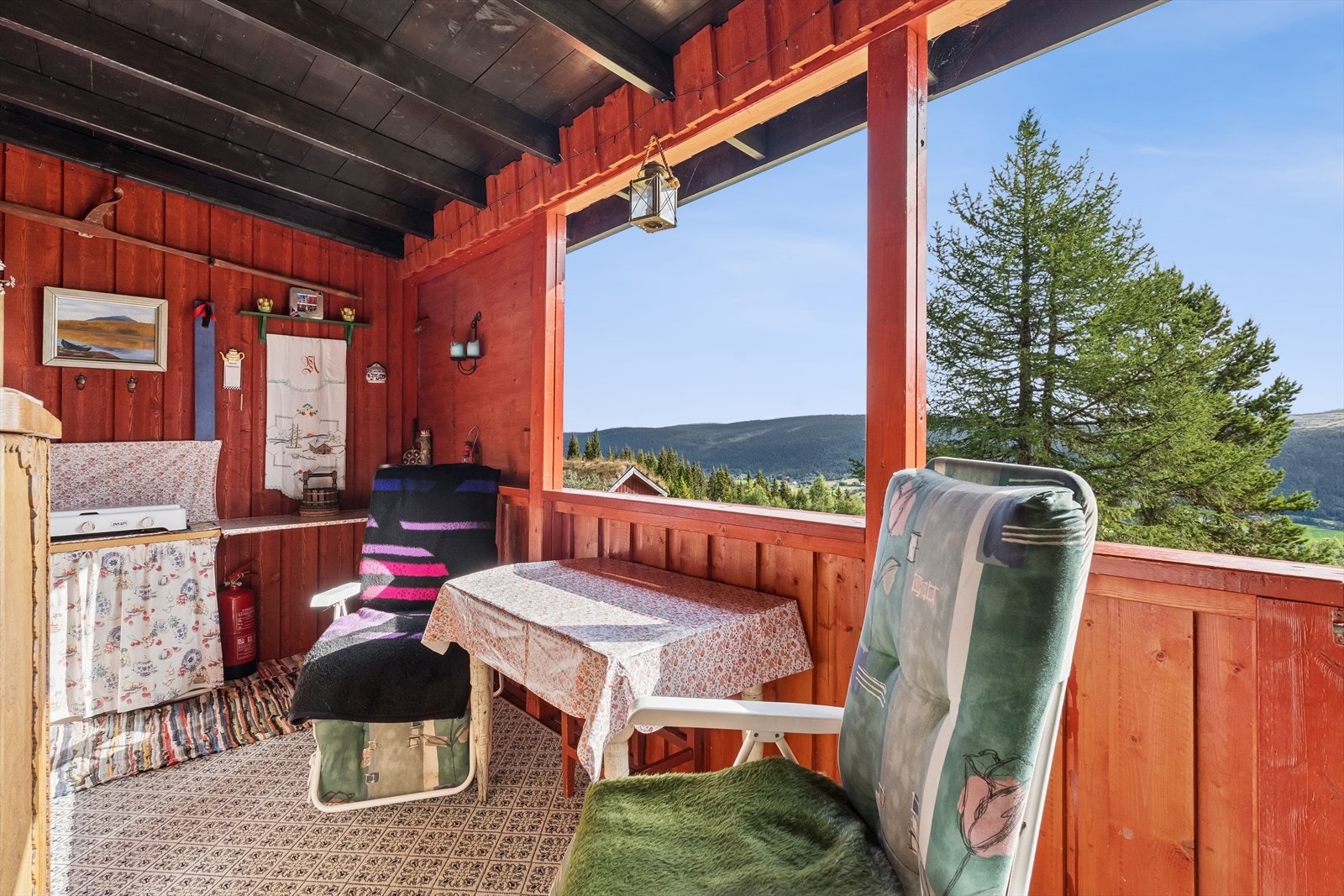 Overbygd veranda med plass til sittegruppe og utsikt over nærområdet. Verandaen kan åpnes og lukkes med plater for å hindre snø/regn inn på veranda. Galleribilde