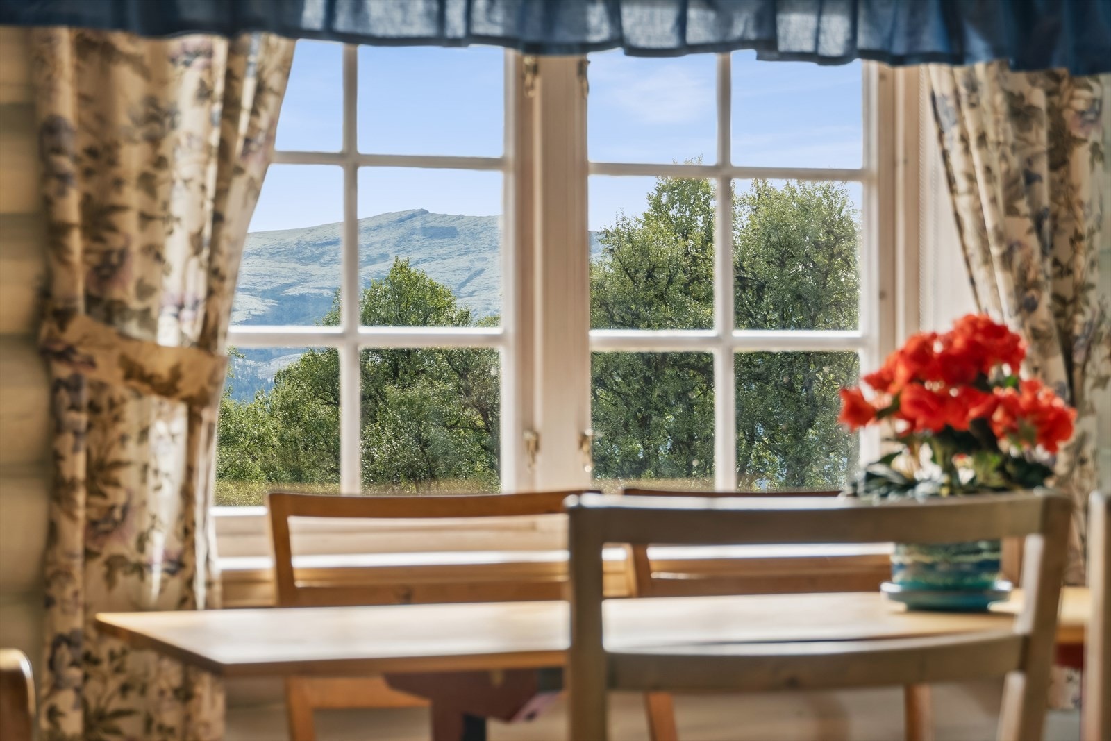 Vinduer med koblede glass rammer inn utsikten mot det omkringliggende landskapet. Galleribilde