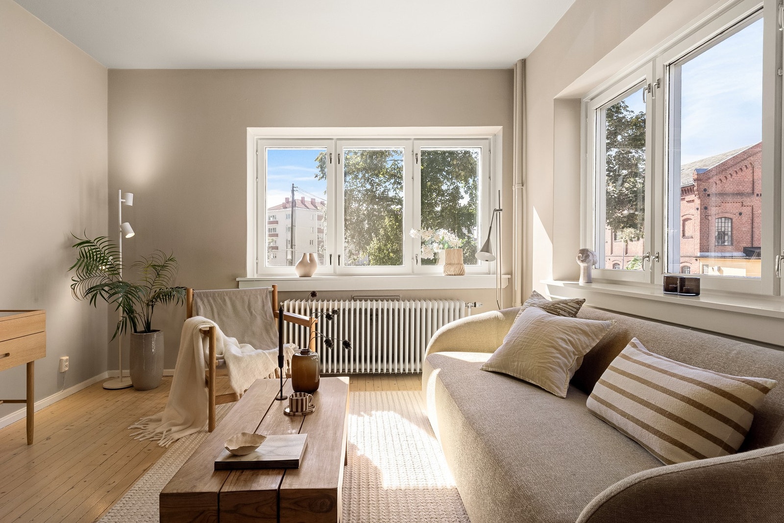 Lys og romslig hjørnestue med store vindusflater som vender mot to himmelretninger, gir rikelig med naturlig lys og grønt utsyn mot parkområde. Galleribilde